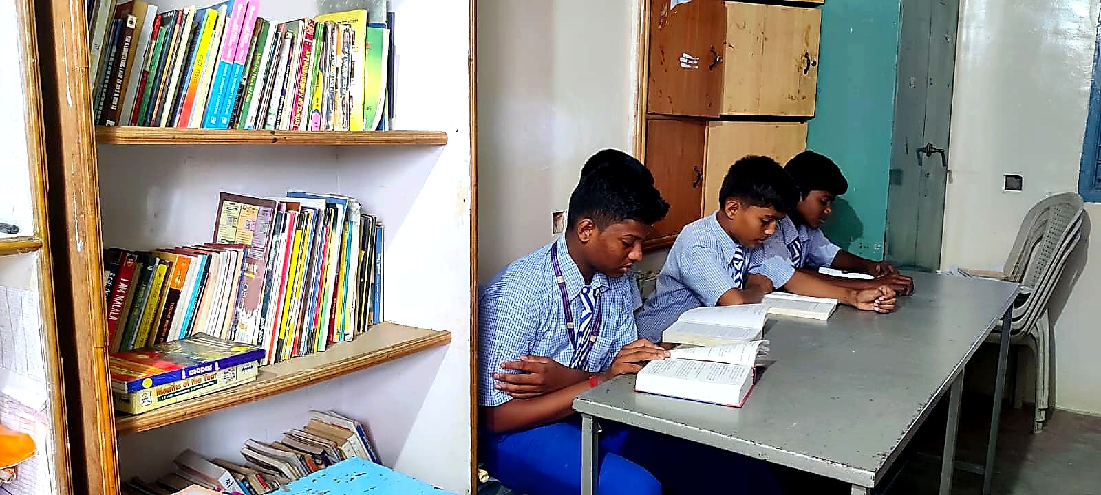 A Manjushree student showing a Kannada book to the school librarian in the library